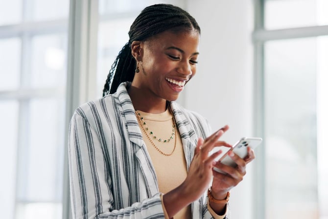 Mulher utilizando celular para conferir seus investimentos em criptos