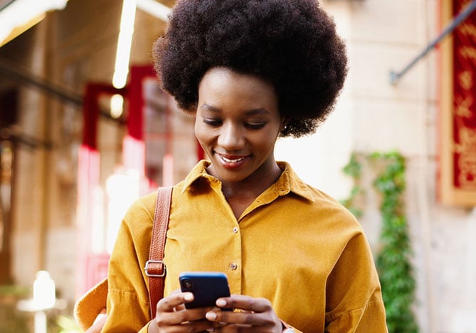 Mulher buscando no celular as vantagens do Open Finance Mercado Pago