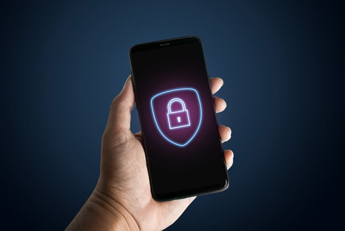 Mercado Pago: mão segurando um celular com um cadeado na tela representando proteção contra golpes virtuais.