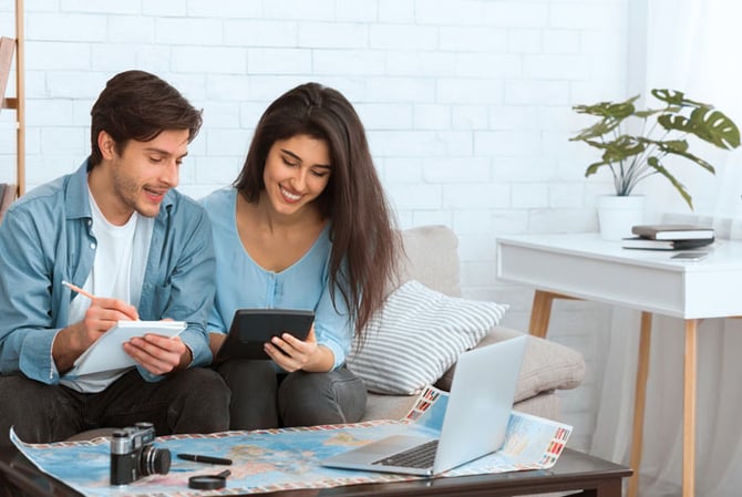 Mercado Pago: homem e mulher sentados no sofá, fazendo contas em papel e calculadora para criar sua reserva financeira 