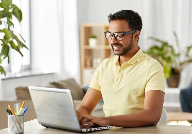 Um homem sorridente mexendo no computador