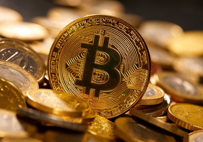 Ilustração de bitcoin através de uma moeda de ouro