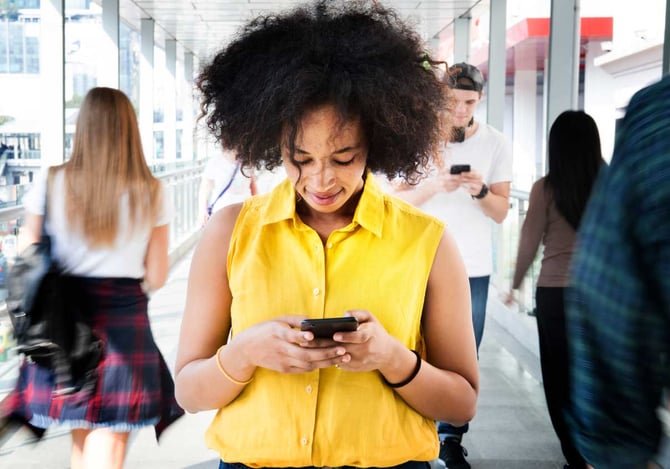 Mulher andando com um celular na mão