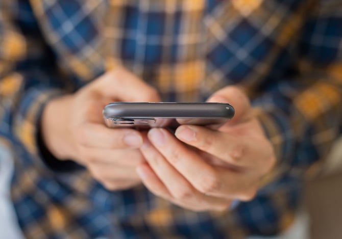 Pessoa segurando seu smartphone com as mãos