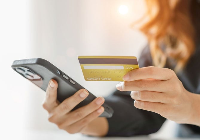 Mercado Pago: Mulher conferindo pelo celular golpe do cartão de crédito