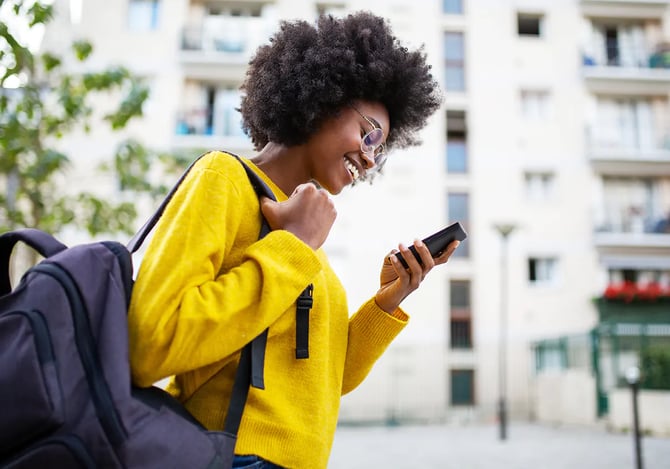 Mulher sorrindo enquanto mexe no smartphone