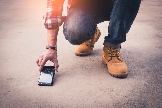 Homem deixou seu celular cair no chão, porém ele conta com o seguro para celular na Conra Mercado Pago