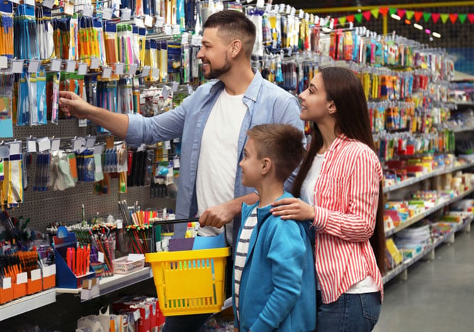 Mercado Pago: pais e filho analisando como economizar no material escolar