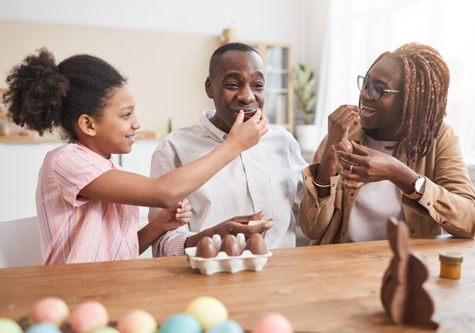 Mercado Pago: família comendo ovos de chocolate como forma de celebração da Páscoa. 