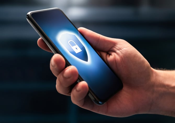 Mercado Pago: mão segurando um celular com um cadeado na tela representando a proteção de dados pessoais.