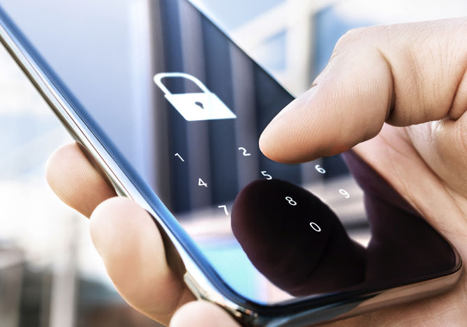 Mão segurando celular com tela de bloqueio com senha ligada, sugerindo a segurança digital proporcionada pela Conta Mercado Pago.