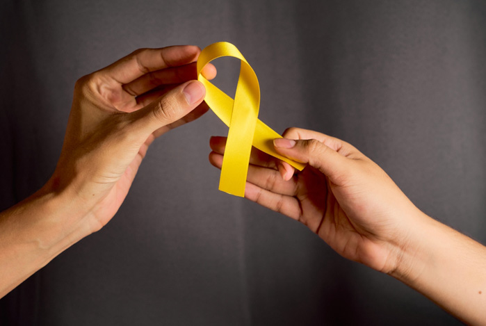 Mercado Pago: duas mãos, uma de cada pessoa, segurando um laço amarelo, que representa a campanha de Setembro Amarelo, que prioriza a saúde mental e mostra como outros fatores como finanças influenciam isso.