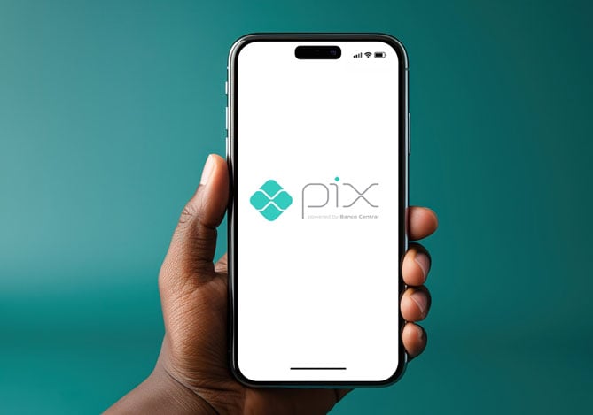 Mercado Pago: mão segurando celular com tela acesa, onde está o símbolo do Pix, representando a Transferência Pix