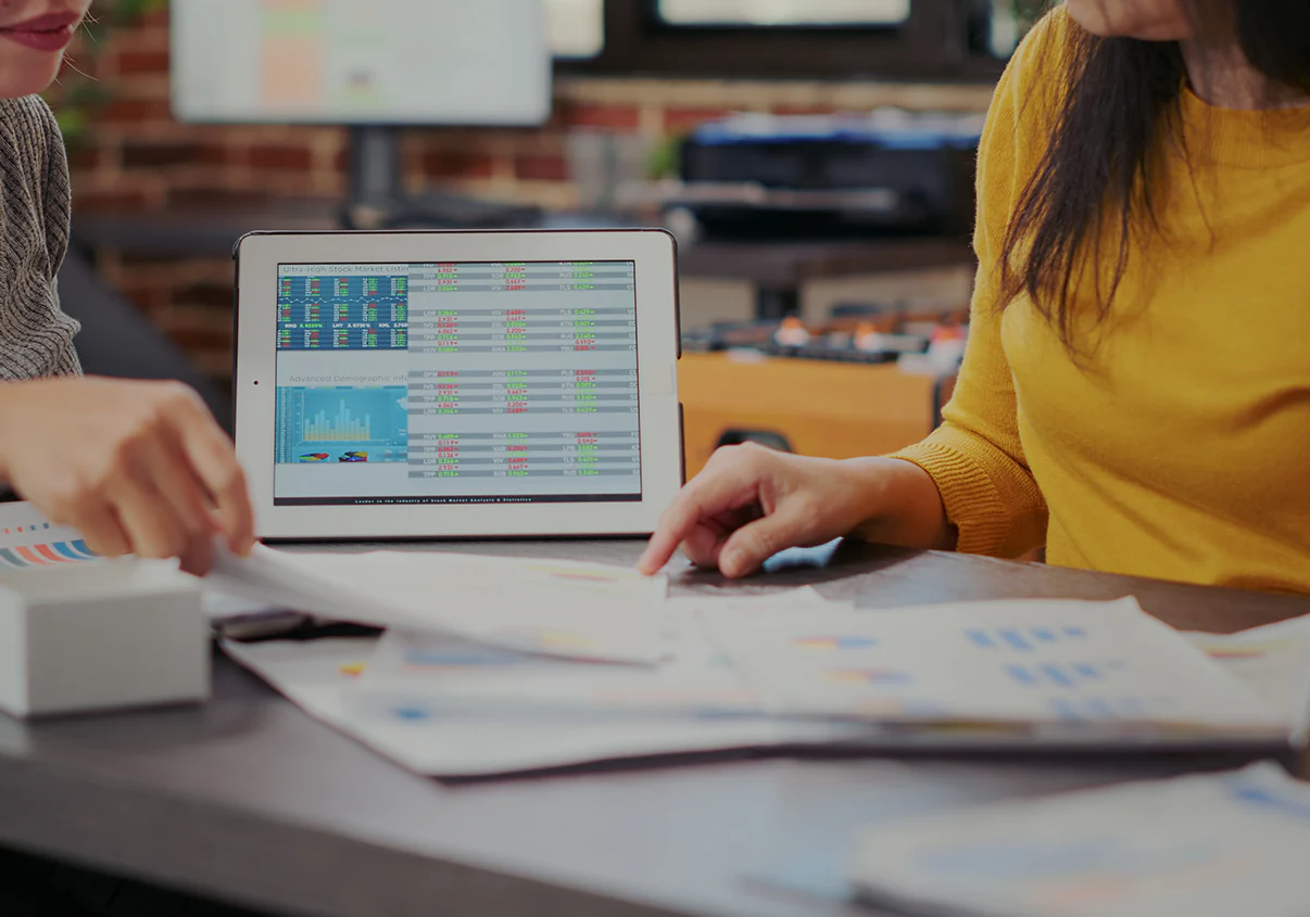 Mulheres analisando dados sobre investimentos no tablet