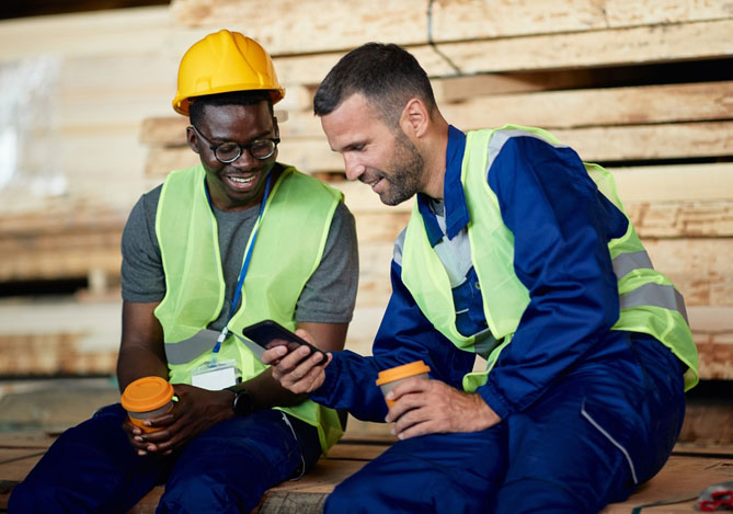 Trabalhadores com celular para consultar benefícios no app Mercado Pago