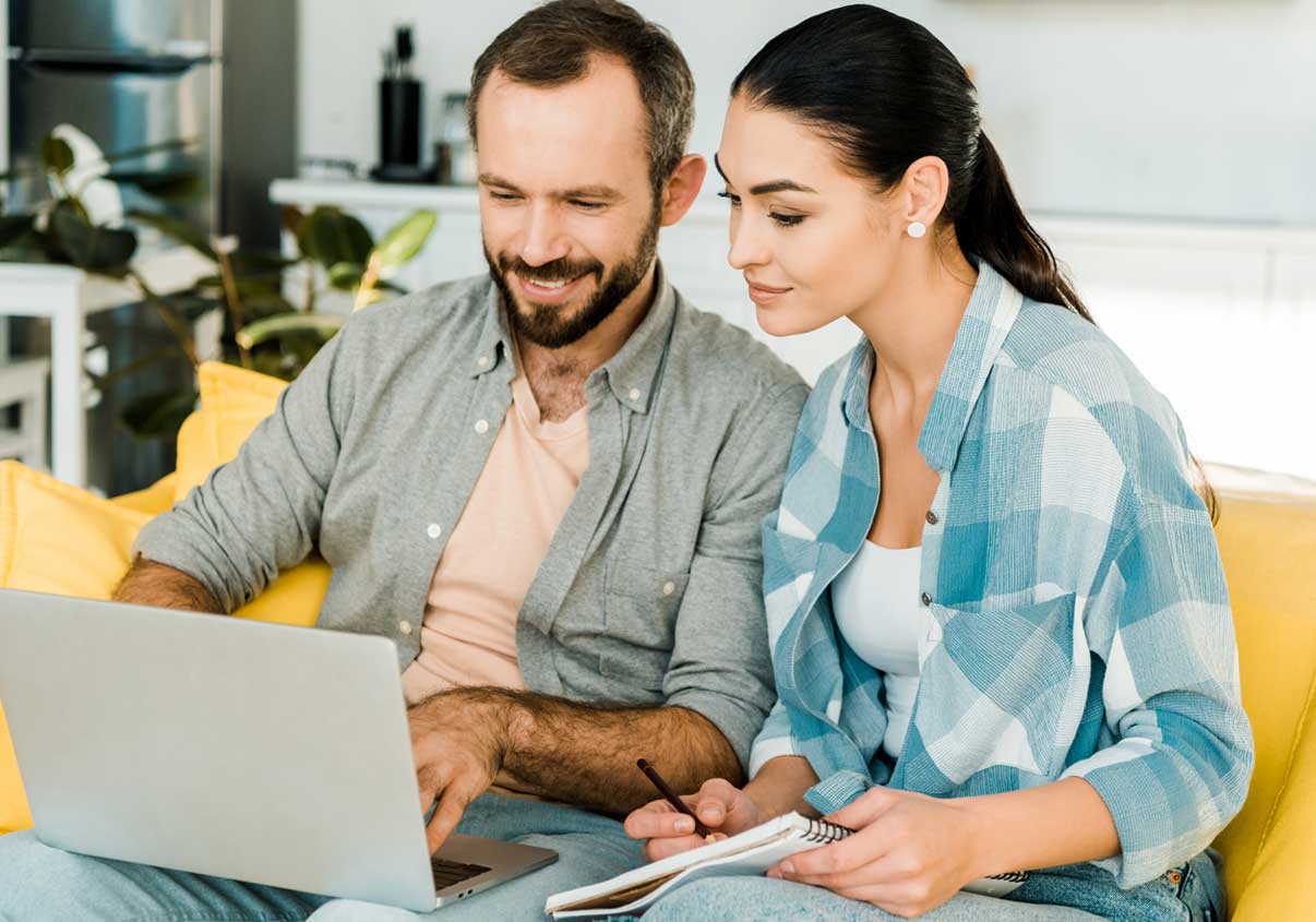 Casal programando o pagamento das contas em débito automático na Conta Mercado Pago