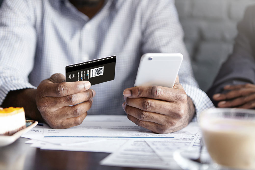 Uma pessoa segurando um cartão de crédito Mercado Pago e na outra mão segurando um celular